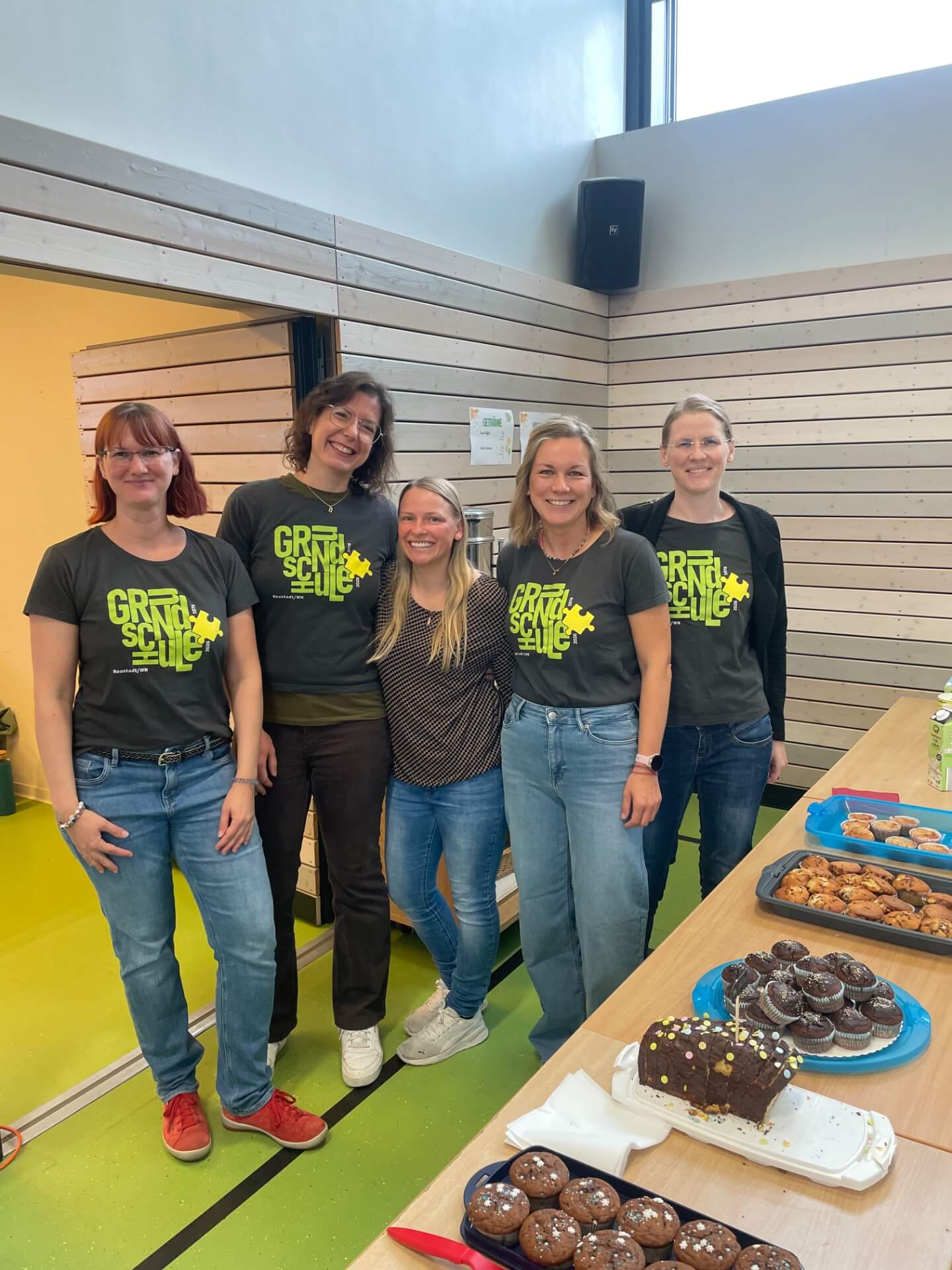 Fünf Frauen des Elternbeirats lachen in die Kamera am Kuchenverkaufsstand
