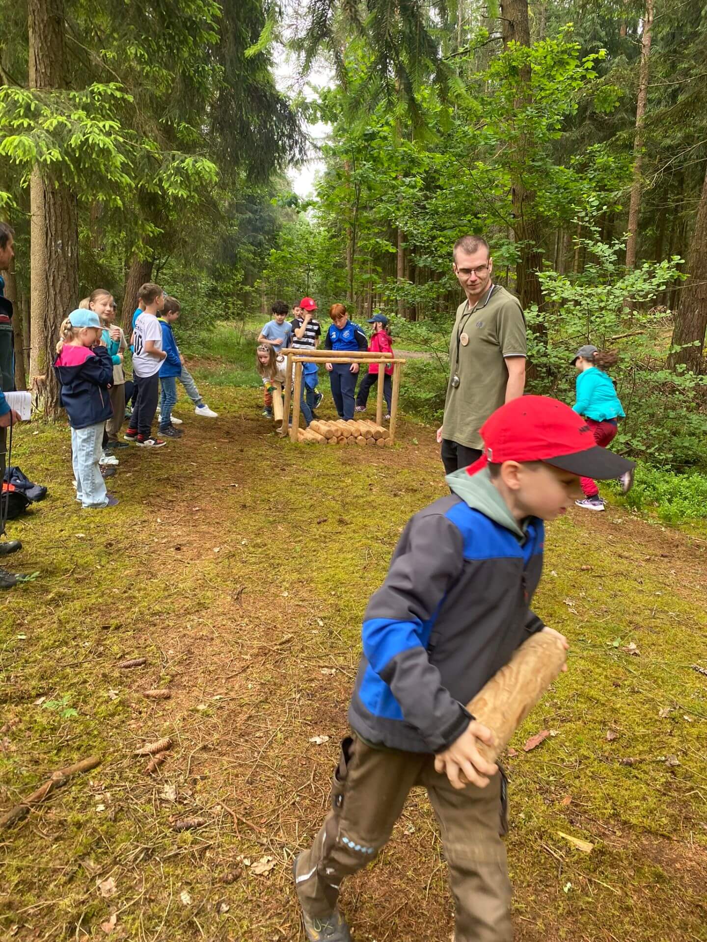Kinder machen Laufspiel mit kleinen Stämmen