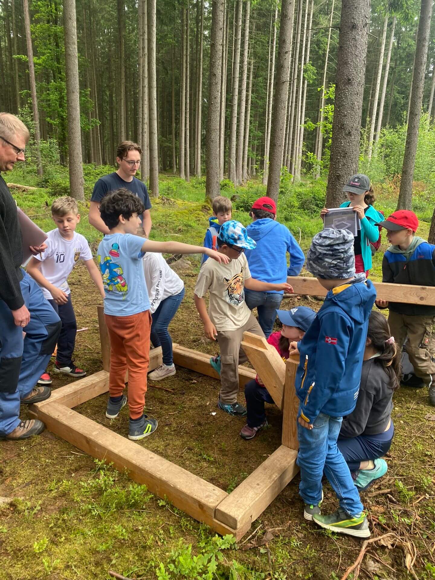 Kinder bauen im Wald einen Dachstuhl