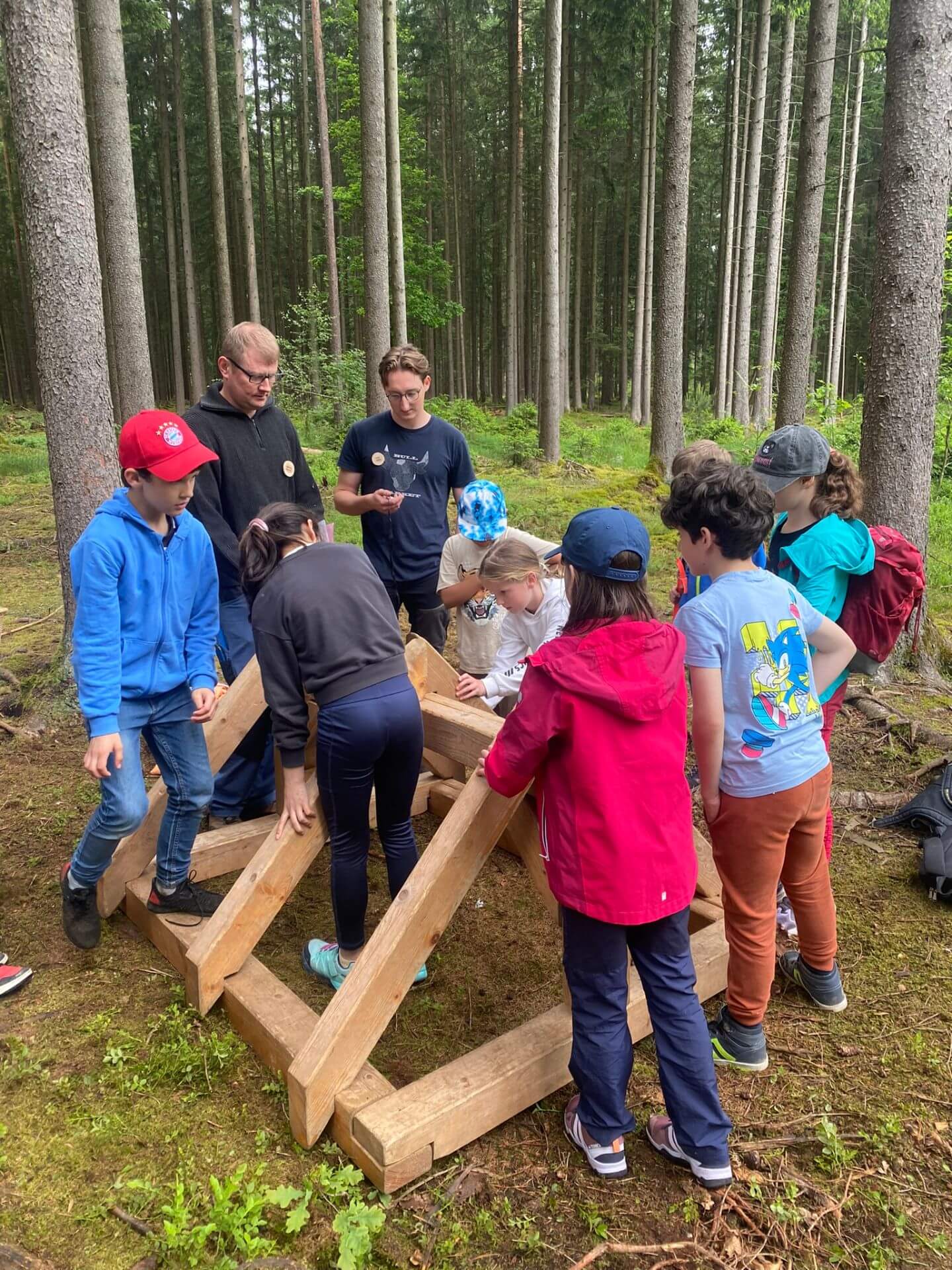 Kinder bauen im Wald einen Dachstuhl