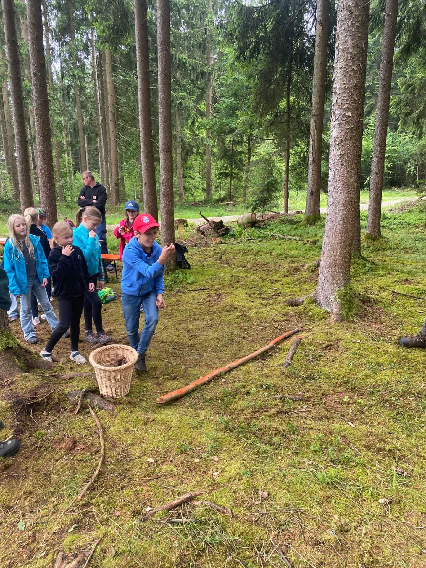 Kinder im Wald bei einem Wurfspiel