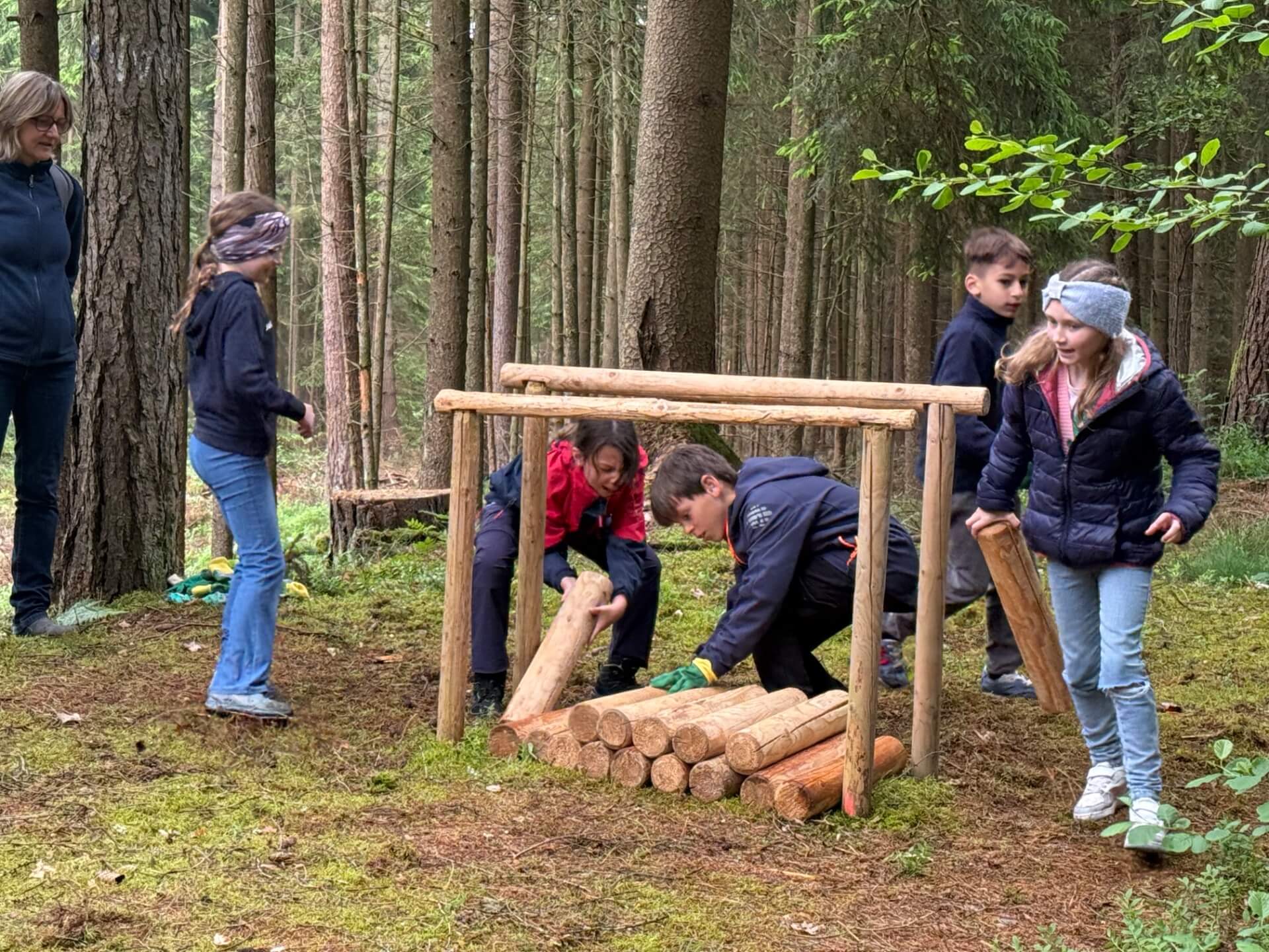 Kinder machen Spiel mit kleinen Baumstämmen